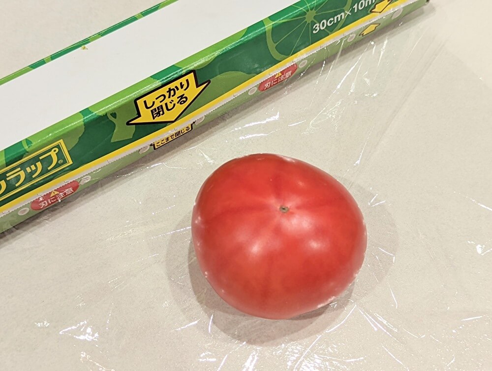 冷凍保存するトマトにラップを巻く